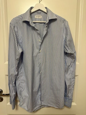 Blårandig skjorta från John Henric - Säljer en klassisk blårandig skjorta från John Henric. Sparsamt använd och väldigt bra skick!