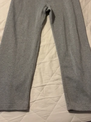 Gråa mjukisbyxor med raka ben - Ett par klassiska grå mjukisbyxor med raka ben och enkel design. Perfekta för chill dagar hemma eller när du vill ha det extra bekvämt. Tillverkade i mjukt sweatshirtmaterial som känns skönt mot huden.