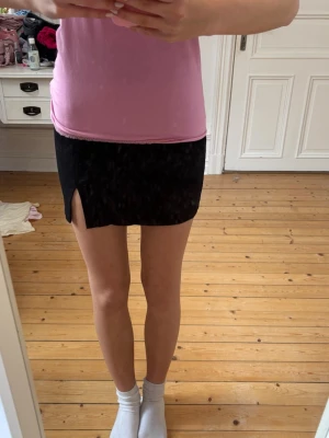 Svart minikjol med slits - Snygg svart kortkjol med en liten slits på sidan. Storlek xxs från Gina Tricot💕