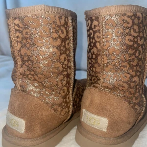 Bruna UGG’s med glitter och leopardmönster🤎🐆 - Säljer ett par AS SNYGGA guld glittriga leopard uggs!!!😍😍😍 Dom är jätte svåra och hitta och dom är även köpta i usa, Dom är limited edition och ger 2000’s vibe! Säljer dom för att dom har blivit för små för mig! 