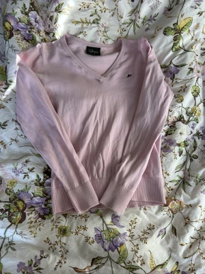 Ljusrosa vintage peak performance tröja💓 - Ljusrosa v-ringad tröja från peak performance med liten broderad logga på bröstet. Tröjan har långa ärmar, ribbade muddar och nederkant. Perfekt för en chill och stilren look.