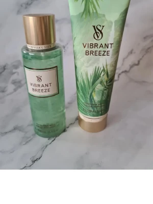 Victoria's Secret Vibrant Breeze set - Vibrant Breeze från Victoria's Secret – ett set med body mist (250 ml) och lotion (236 ml). Doftnoter av kokosnötsskal och sandelträ, inspirerat av djungeläventyr. Vegan formula och förpackning delvis av återvunnet material. Helt nytt och oanvänt men lite mindre mängd i flaskan, var så när jag fick den