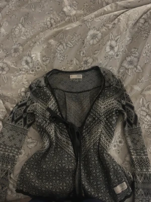 Odd Molly kofta med mönster  - Märke: Odd Molly  Storlek: 0 (motsvarar XS-S) Färg: Svart, vit, grå  Utseende: En snygg kofta i skönt material som är mönstrat. Går att knyta i midjan och är utsvängd