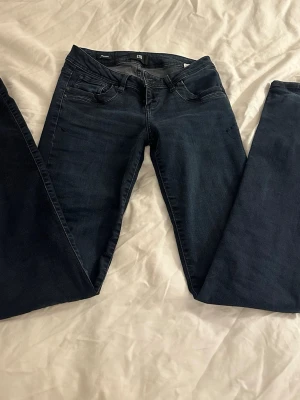 Mörkblå bootcut jeans från LTB -  Säljer ett par snygga mörkblå LTB jeans eftersom det aldrig kommer till användning. Jag är 164 cm lång. Innebenslängden är 83 cm och midjemåttet är 38/39 cm 