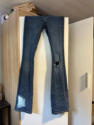 Blå bootcut jeans med hål - Blå bootcut mid waist jeans med ett hål på ena knät, snygga och passar långa personer som har svårt att hitta jeans till sig. 