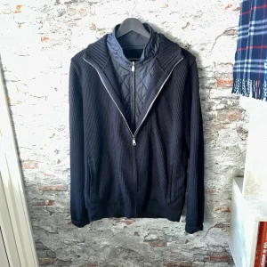 Hackett London cardigan - Tvärfet och unik, tillverkad av skön ull. Mycket bra skick, inga defekter! Passar dig som är mellan 185-195cm ungefär. Nypris ca 3000kr. Modellen är 185 cm, 75kg. Passar bra nu till våren! Skriv för mer information!🤝