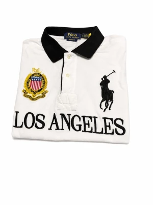 Vit pikétröja Polo Ralph Lauren - Vit pikétröja från Polo Ralph Lauren där det står LOS ANGELES. Väldigt bra skick då jag har använt den ett få tag gånger. Fråga gärna om du har några frågor eller funderingar! Fraktar inom 24h🚚