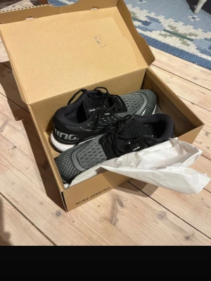 Svarta löparskor från Salming - Säljer ett par svarta och grå löparskor från Salming med vita detaljer och tjock, dämpad sula. Skorna har meshmaterial på ovandelen för bra ventilation och snörning för perfekt passform. De är endast testade och i nyskick! 