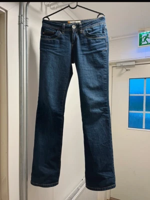Mörkblå bootcut jeans från G-Lago - Snygga mörkblå jeans från G-Lago med bootcut passform. Jeansen har en låg midja och tydliga sömmar, samt en patch med logga bak. Storleken är W: 28 L: 34. De går ner till marken på mig som är 170! 