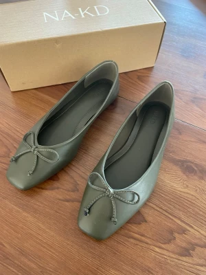 Oanvända khakigröna ballerinas  - Stilrena khakigröna ballerinas från NA-KD med fyrkantig tå och dekorativ rosett framtill. Helt oanvända då storleken inte passade, 37 i storleken. 