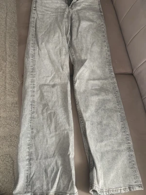 Grå raka jeans från Perfect Jeans - Snygga grå jeans från Perfect Jeans med rak passform och klassisk femficksdesign. Jeansen har en ljusgrå tvätt och är tillverkade i denim med en stilren look. Perfekta för dig som gillar en avslappnad och trendig stil.