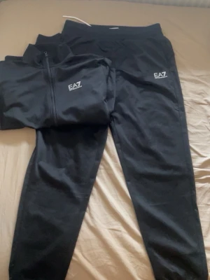 Svart tracksuit  EA7 Emporio Armani - Säljer ett svart träningsset från EA7 Emporio Armani nästa aldrig använt köpt nyligen.