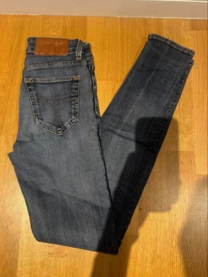 Blåa jeans märke tiger of sweden  - Snygga mörkblå jeans med klassisk och Perfekta för en avslappnad och trendig look. Märke tiger of sweden 