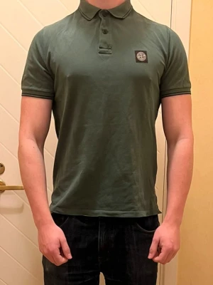 Stone Island pike  - Här kommer en väldigt trevlig och stilren Piké från Stone Island, tröjan är slim fit och sitter väldigt bra över armar och axlar, funkar utmärkt nu till sommaren när du vill visa folk att du faktiskt har tränat! 