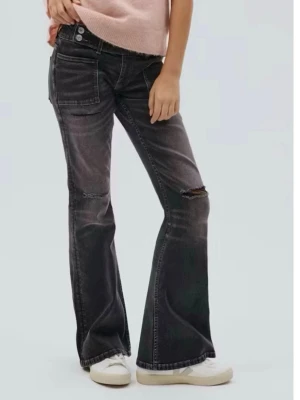 Svarta bootcut jeans med slitningar - Säljer ett par svarta bootcut jeans med slitningar på låren och knäna. Jeansen har stora framfickor, dubbla knappar i midjan och en tvättad look. Perfekta för dig som gillar en avslappnad och trendig stil.