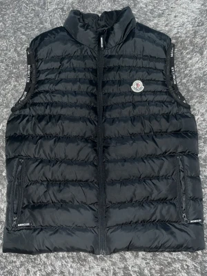 Becknar väst moncler väst  - Fet svart Moncler väst. Västen har två fickor med dragkedja utanför och en med dragkedja inuti för o gömma saker 😉. Och den sähhhiga Moncler loggan på bröstet. Perf för de kommande vår vädret. Bara använd ett väldigt fåtal gånger. Bra kvalite.