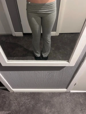 Grå yoga pants  med utsvängda ben - Säljer ett par grå yoga pants med utsvängda ben och bred linning i midjan. Byxorna är i mjukt och stretchigt material, perfekta för chill dagar hemma eller när du vill vara bekväm. Passar dig som gillar en enkel och clean stil. Korrekt storlek är 146/152 i barnstorlek.