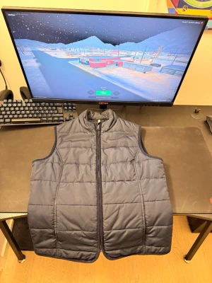 Mörkblå dunväst från Berkeley ÄKTA! - Snygg mörkblå dunväst från Berkeley med quiltad design och dragkedja framtill. Västen har hög krage och är perfekt för lager-på-lager-stil. Tillverkad i ett mjukt och lätt material som håller värmen utan att kännas klumpig. Ny pris är 1400. Pris kan diskuteras!