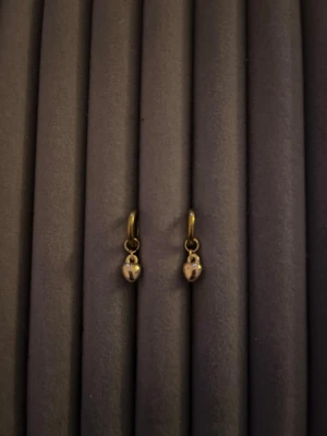 Guldiga hoops med små droppar - Snygga örhängen i guldig metall med små droppformade hängen. Enkla hoops som passar perfekt för dig som gillar minimalistisk stil. Ingen synlig märkning på örhängena. Perfekta att mixa och matcha med andra smycken.