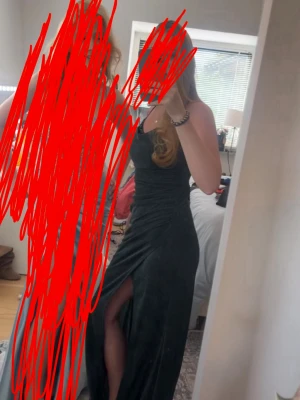 Mörkgrön långklänning med slits - Säljer nu min balklänning. Snygg mörkgrön långklänning med smala axelband och hög slits på sidan. Klänningen har en figurnära passform, den är från jjs house i glittrande material med paljetter längst upp.