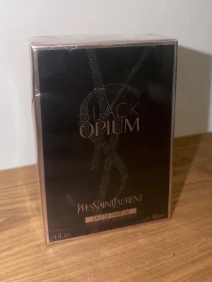 Yves Saint Laurent Black Opium parfym - Black Opium Eau de Parfum från Yves Saint Laurent. Lyxig parfym i svart och roséguld förpackning med ikonisk YSL-logga. Flaskan rymmer 90 ml och doften är känd för sina intensiva och sensuella toner.