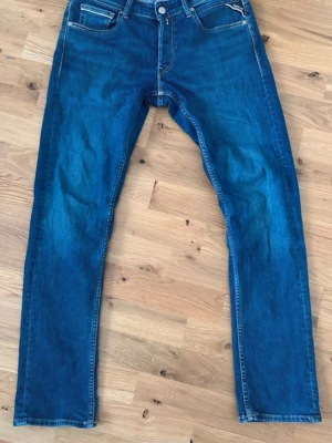 Replay Grover jeans - Snygga blå jeans från Replay med klassisk femficksdesign och raka ben. Jeansen har normalhög midja och tydliga kontrastsömmar. Tillverkade i denim med en autentisk tvättad look. Perfekta för en avslappnad stil.