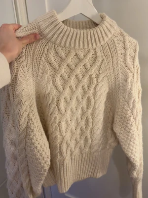Vit stickad tröja - Säljer denna jättemjuka stickade tröja från H&M i storlek XS, då den inte kommer till användning! Färgen är benvit💕använd ett fåtal gånger! Passar perfekt nu till våren🫶🏼