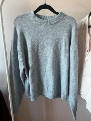 Ljusblå stickad tröja från H&M - Mysig ljusblå stickad tröja med rund halsringning och långa ärmar från h&m.