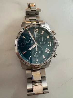 Certina ds podium - Stilren Certina Ds Podium chronograf herrklocka med silverfärgad länk i metall och grön urtavla. Riktigt snygg! Nytt batteri och provtryckt i januari 26.Klockan har kronograf, datumvisning och tydliga siffror. Perfekt accessoar för dig som gillar klassisk design med sportig touch. Nypris mellan 5300-6500kr.