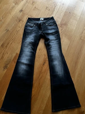 Svarta bootcut jeans från GT - Säljer ett par svarta bootcut jeans från Gina Tricot med snygg tvätt och utsvängda ben. Klassisk femficksmodell och låg midja. Perfekta för dig som gillar retrovibbar och vill ha ett par jeans som sticker ut.