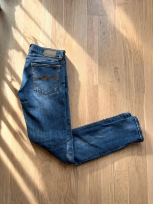 Nudie jeans lean dean blå  w31/l34 - Säljer ett par riktigt schysta nudie jeans i modellen lean dean. W31/l34  Jeansen har fem fickor, normal midja och en snygg tvätt med lätt slitning på låren. Tillverkade i mjuk bomullsdenim med Nudie-logga på bakfickan. Perfekta för en avslappnad och trendig stil. De är sparsamt använda. Skick 9/10 Priset kan diskuteras, hör av er vid frågor 👍