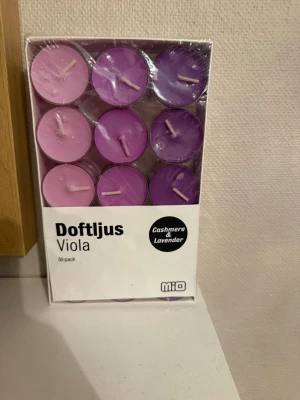 Doftljus Viola Cashmere & Lavender - Säljer ett 30-pack doftljus från Mio i serien Viola. Ljusen kommer i olika nyanser av lila och rosa och har doft av cashmere och lavendel. Perfekta för att skapa mysig stämning hemma. Förpackningen är genomskinlig och visar ljusen tydligt. Har inte öppnat den än så den är helt ny