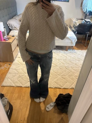 Beige kabelstickad tröja - Säljer en beige kabelstickad tröja med rund hals och vida ärmar. 