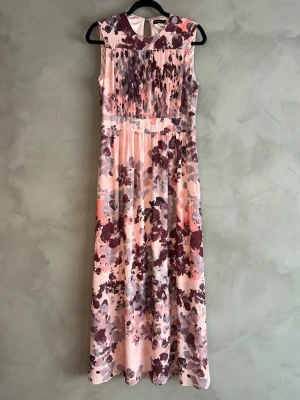 Stockh LM blommig maxiklänning rosa 38 – elegant fest - Elegant maxiklänning från Stockh LM i rosa blommigt mönster. Plisserad överdel och fint fall i kjolen. Perfekt till fest, bröllop, student eller sommarkvällar.  Storlek: 36 Skick: Fint skick Lång modell med smickrande passform. Väldigt feminin och stilren.