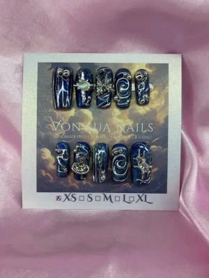 CosmicDrip(XS);Medium Square;Curved - Unika handgjorda press-on naglar i djupblå färg med silverfärgade 3D-dekorationer, stjärnor och swirl-mönster. Naglarna har en glansig finish och coola handmålade metalliska detaljer som ger en futuristisk vibe. Perfekt för dig som vill sticka ut med handgjorda, konstnärliga naglar.XS: 14 mm, 11 mm, 11,5 mm, 10 mm, 8 mm 