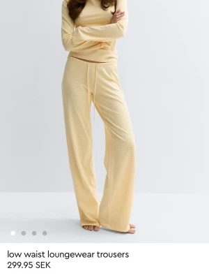 Gula low waist loungewear-byxor - Säljer ett par ljusgula loungewear-byxor med låg midja och avslappnad passform. Byxorna har dragsko i midjan och är tillverkade i ett mjukt, ribbat material som känns skönt mot huden. Perfekta för chill dagar hemma.