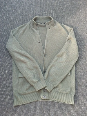  Kofta från Massimo Dutti - Snygg kofta från Massimo Dutti med ståkrage och knäppning framtill. Koftan har två stora fickor, ribbade muddar och är stickad i ett mjukt material. Perfekt för lager på lager och enkel att matcha med olika outfits. Jättefint skick i storlek L