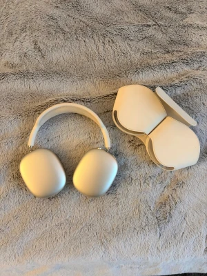 Apple AirPods Max starlight med fodral - Säljer ett par stilrena Apple AirPods Max i silver. Over-ear design med mjuka öronkuddar och justerbart huvudband i mesh. Tillverkade i aluminium och textil. Medföljer matchande smart case för enkel förvaring och skydd.