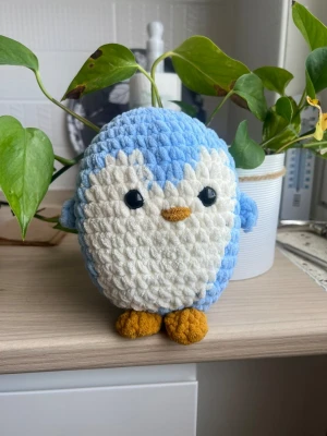 Blå och vit pingvin mjukisdjur - Supergulligt mjukisdjur formad som en pingvin med blått och vitt fluffigt tyg, svarta plastögon och orange näbb och fötter. Perfekt som dekoration eller kramkompis. Rund och kompakt design.