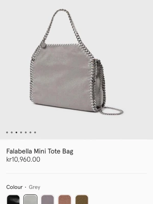 Grå Falabella Mini Tote från Stella McCartney - Säljer en grå Falabella Mini Tote Bag från Stella McCartney. Väskan har kedjedetaljer i silver runt kanterna och som axelrem. Tillverkad i veganskt mockaliknande material.