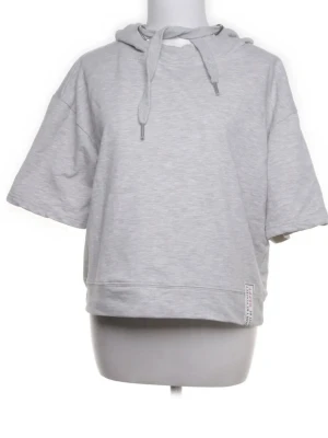 Ljusgrå hoodie från Page One - Kortärmad ljusgrå hoodie från Page One med huva och dragsko. Oversized passform och mjukt sweatshirtmaterial i bomullsblandning. Liten etikett nertill på framsidan för extra detalj. Perfekt för en avslappnad och trendig look.