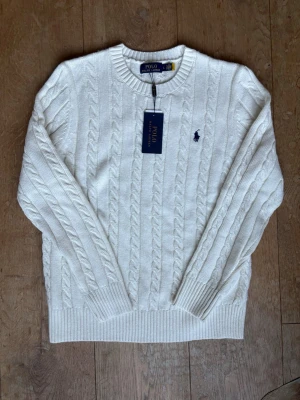 Ralph lauren knit - Säljer denna ikoniska Ralph lauren kabel kniten, den är helt ny och helt oanvänd. Den passar till alla säsonger men kanske bäst nu på våren. Storleken är L men den sitter som M-S. Tveka inte på att höra av er vid frågor och priset kan diskuteras!