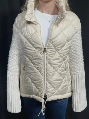 Quiltad beige jacka med stickade ärmar - Hej! Säljer min underbara jacka ifrån Second Layer Bc eftersom passformen tyvärr inte passar mig. Jackan några få knottrar vid ärmarna men det syns ej om man inte tänker på det,  dragkedjan vara en aning trög. Är 178 och har S i storlek, men eftersom min överkropp är längre satt jackan inte så som jag tänkte mig, därför säljer jag. Hör av er vid frågor och funderingar!💘OBS den är lite mer beige i verkligheten
