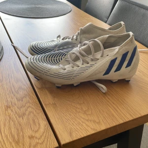 Ett par adidas predator fotbollsskor  - Säljer ett par vita adidas predator fotbollsskor som är använda ett få tal gånger, ordinarie pris 2200
