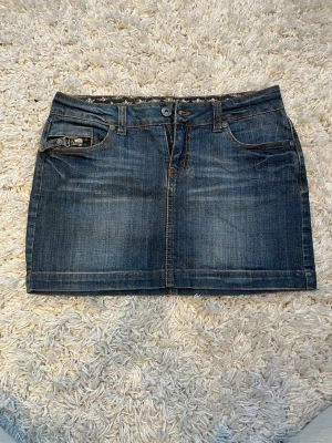 Jeanskjol från Only - Supersnygg jeanskjol med låg midja från Only.  En cool detalj med dragkedjor på fickorna. Midjemått rakt över: 36 cm & 32 cm lång💘