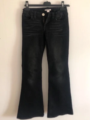 Svarta bootcut jeans med detaljer - Säljer ett par svarta low waist flare jeans med snygga slitningar och dekorativa sömmar på bakfickorna. 🤩