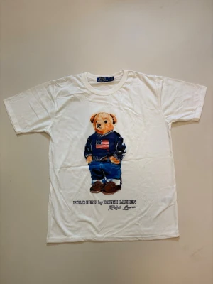 Vit Ralph Lauren T-shirt - Vit Ralph Lauren Polo bear T-shirt // mycket bra skick aldrig använda // storlek L // mått, längd 67cm Axelbredd 43cm // Skriv vid minsta fråga eller fundering🤝