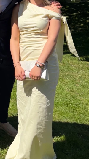 Ljusgul klänning💛 - Ljusgul balklänning/finklänning  från peppermayo💛 storlek 34. Köpte för 800kr. Oneshoulder och knyt på ena armen. Slits på sidan🩷Endast använd 1 gång 