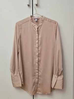Guldig satin skjorta - 🌷FÖRST TILL KVARN!🌷 En superfin skjorta gjord av satin. Skjortan är ut den tunnare sidan och har en fin glansig yta, utan att kännas plastig. Fin i sig själv eller att ha under en väst. Vill bli av med ASAP!