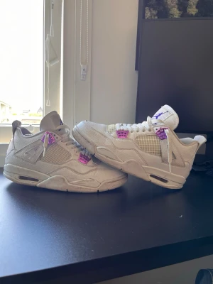 Vita Nike Air Jordan 4 purple metalic - Säljer ett par vita Nike Air Jordan 4 purple metallic. Sitter riktigt bra på foten, dock börjar bli lite slitna på utsidan.
